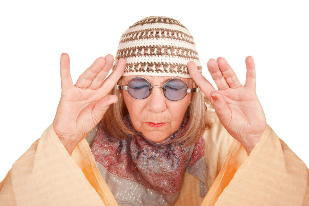 Crazy new age woman in a yellow robe concentrating, old woman, (PantherMedia/Scott Griessel/Scanpix)